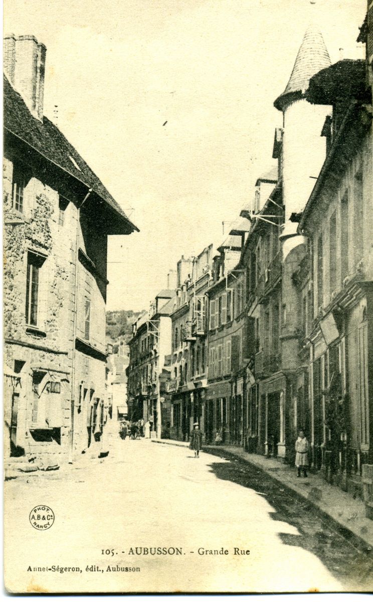 Carte postale de la fin du 19e siècle, montrant la Grande Rue, avec la maison Rogier, avant reprise des parties hautes de sa façade. L'élévation ne comportait alors que deux étages carrés, couronnés par deux lucarnes à croupe débordante (AC Aubusson)