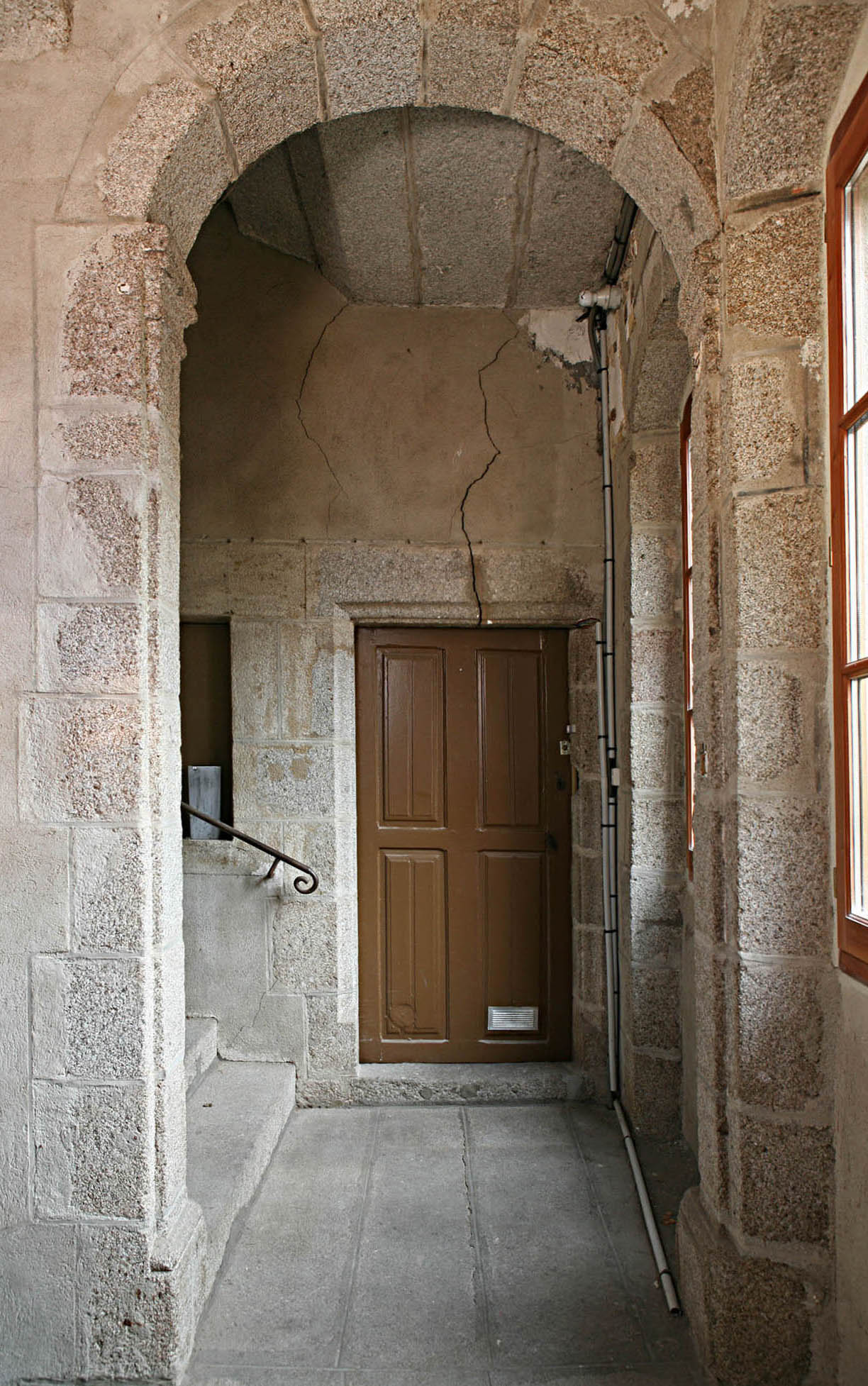 Intérieur de la tour hors-oeuvre. Vue partielle, depuis le second étage, montrant l'ouverture en plein cintre, reposant sur des pilastres à tailloir saillant, percée dans le mur-noyau au niveau du repos.