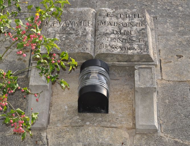 Au-dessus de la porte : détail de l'Evangile sculpté.