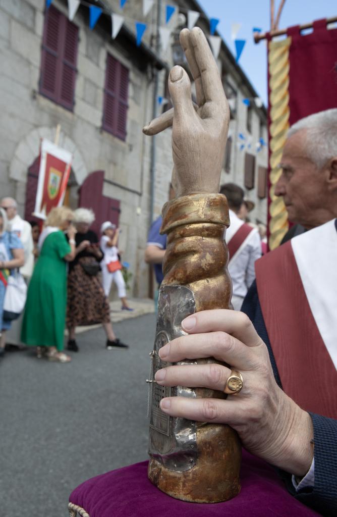 Bras reliquaire sur son coussin de procession tenu par un confrère.