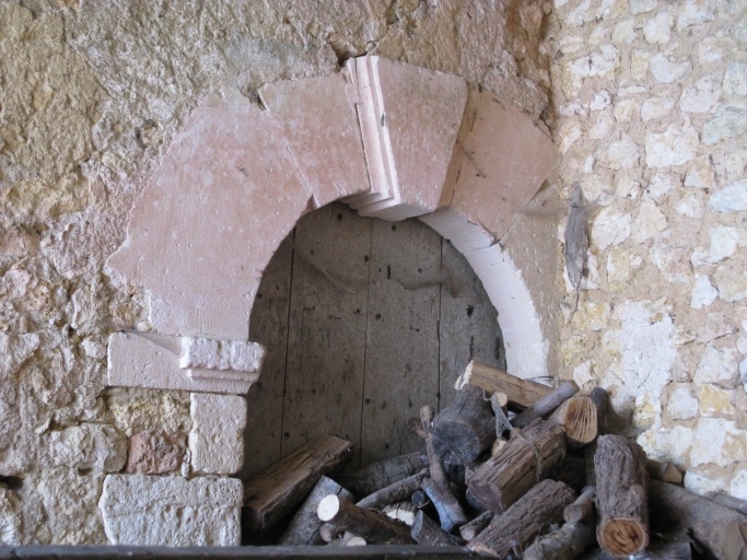 La porte en plein cintre, sans doute du 18e siècle, sous le hangar.