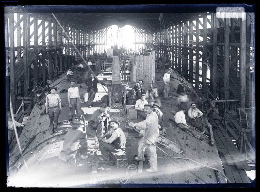 Intérieur d'une cale de construction : ouvriers travaillant sur le croiseur Dupleix lancé le 28 avril 1900.