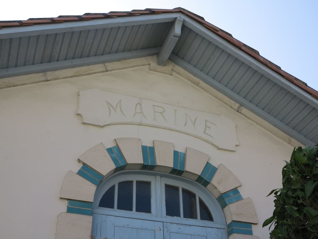 Débordement de toit, cartouche et linteau en brique et pierre.