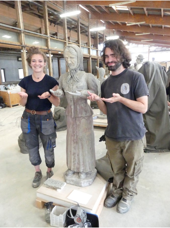 Sculpture de la femme au foulard après la première semaine de chantier, encadrée par les deux étudiants chargés de sa restauration.