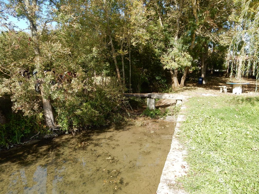 Retour du quai le long du fossé ouest qu'une passerelle en pierre permet de franchir.