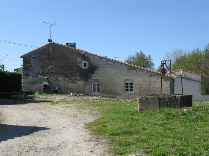 Le logis, les dépendances en appentis à l'arrière et le puits vus depuis l'est.