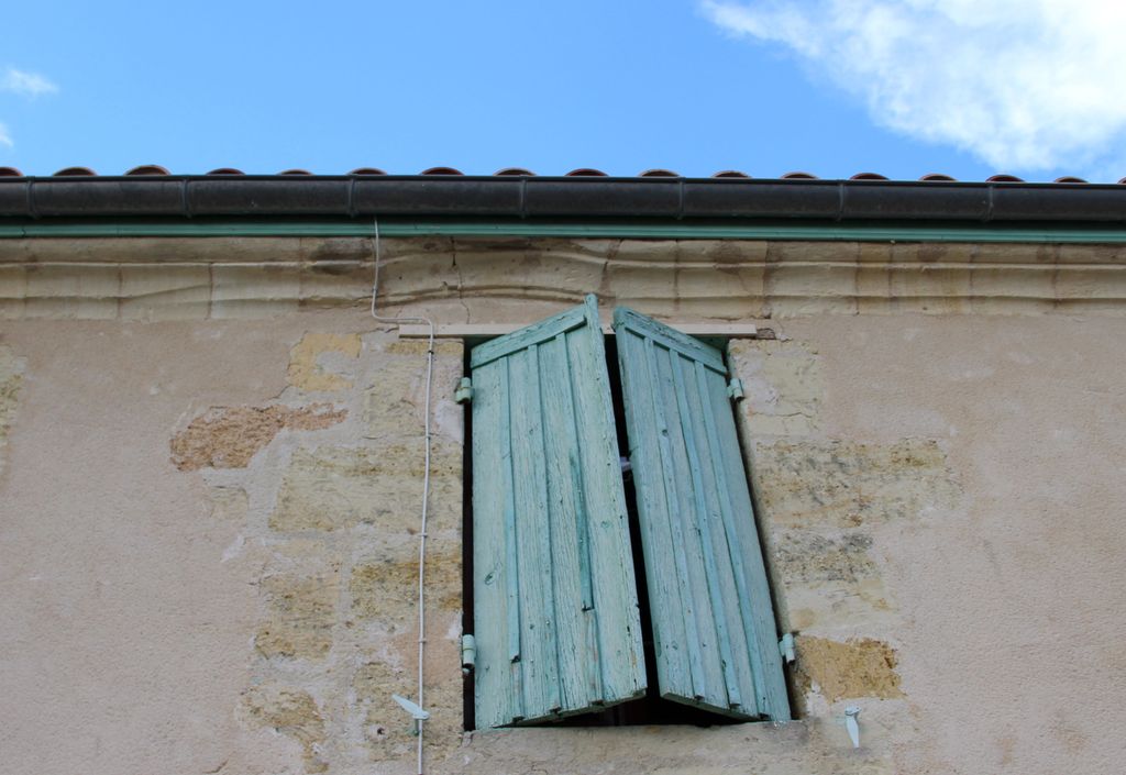 Détail de  l'arc segmentaire de la fenêtre de l'étage formant ressaut dans la corniche.