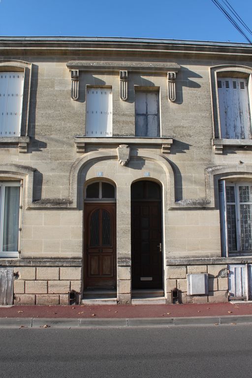 Détail de la façade des maisons jumelles à étage carré.