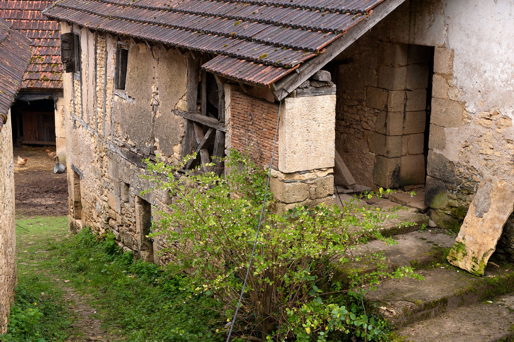 Vue du balet : escalier en pierre, évier (à fond de brique) et structure en pan-de-bois.