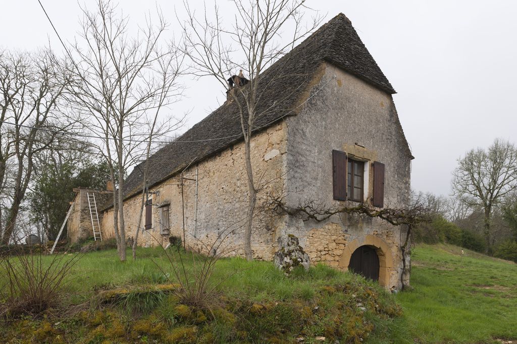 Vue au nord du logis de la ferme ouest (AW 52) du manoir ; porte du chai ouvrant le niveau de soubassement.