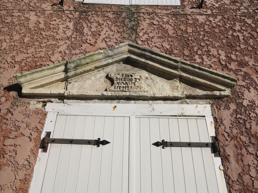 Le fronton et l'inscription de 1590 sur le mur pignon ouest.