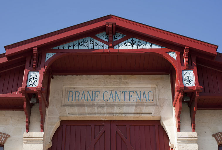 Cuvier, façade-pignon sud-est : détail de la toiture débordante et des motifs en bois ajourés.