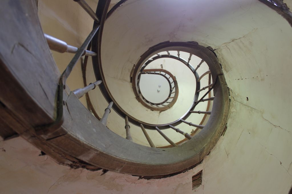 Vue en contre-plongée de l'escalier secondaire en bois.