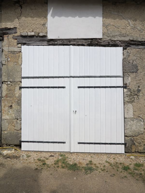 Vestige de lit de pierre au-dessus d'un linteau de porte-charretière dans le bourg de Jouhet.