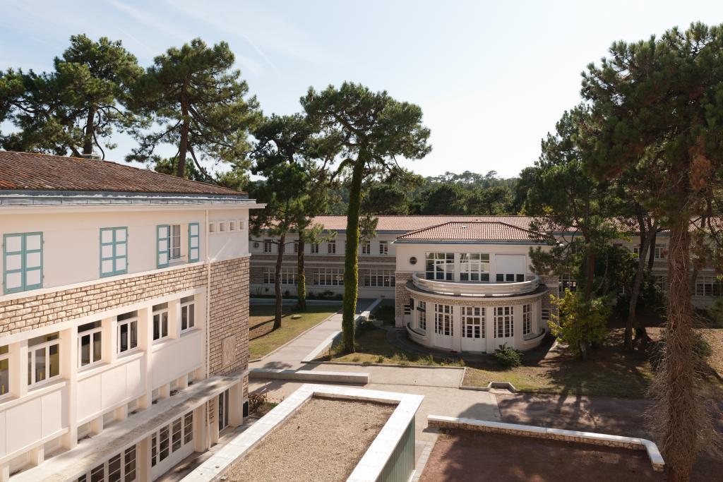 Aile en retour au fond et bâtiment de classes et dortoir au premier plan.