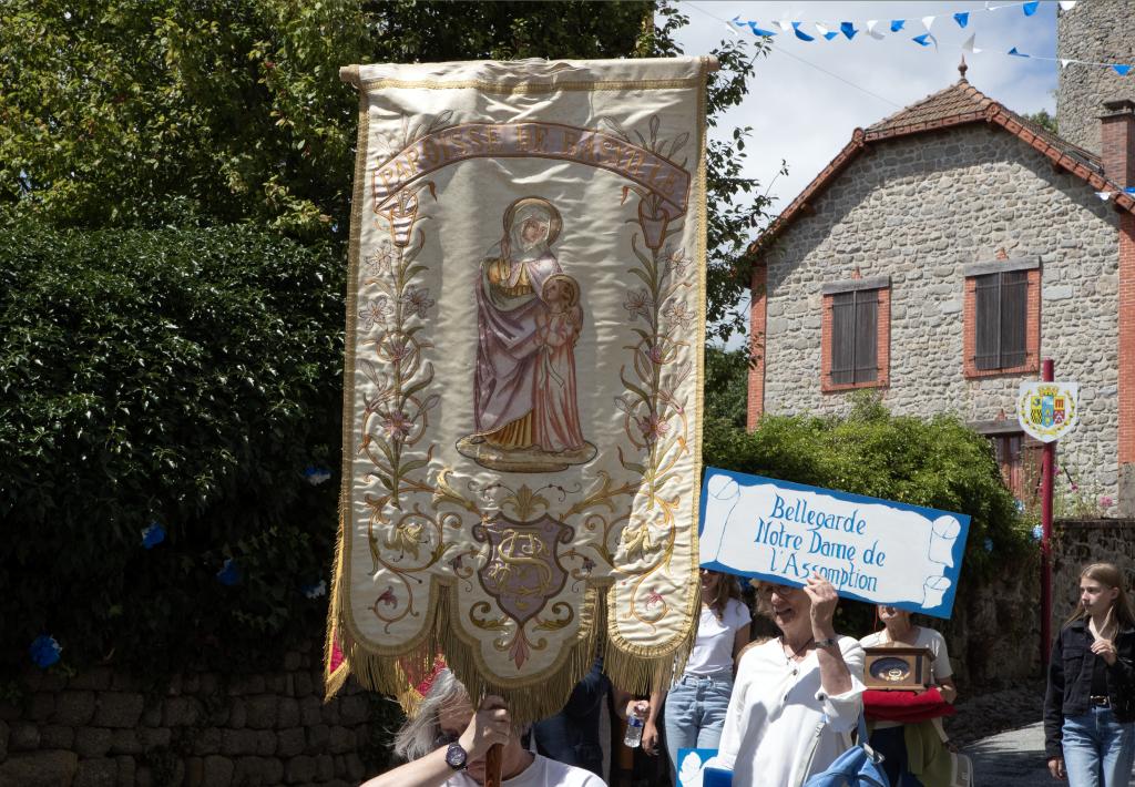 Procession derrière une bannière dans les rues du village.