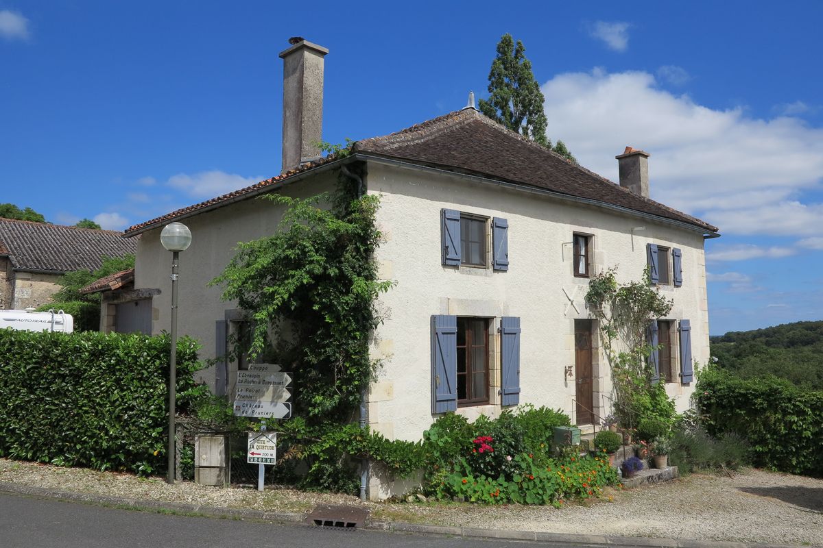 Maison avec croupe en tuile plate en façade, dans le bourg. Elévations nord et ouest de la maison.