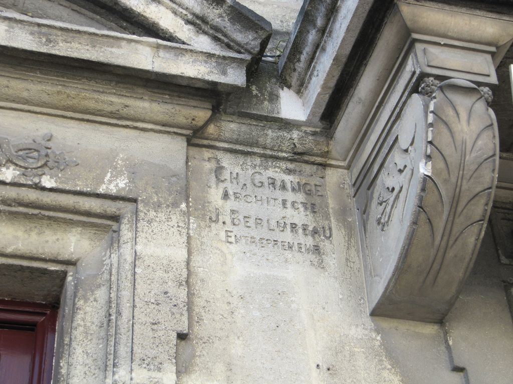 Façade sur le cours : détail de la signature.