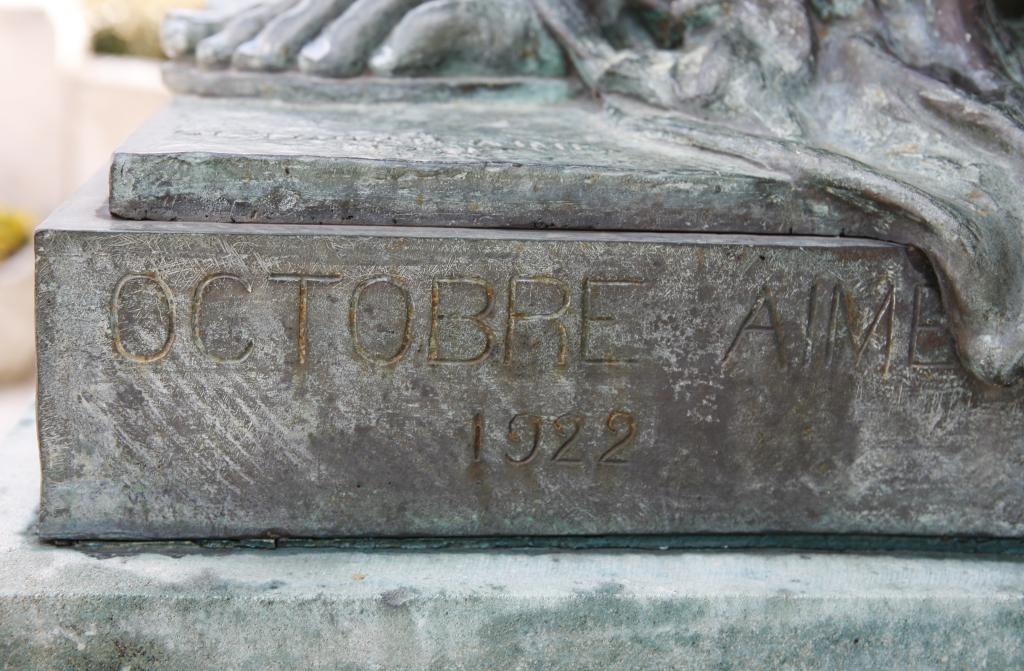 La signature Octobre Aimé et la date 1922 sur la terrasse du socle.