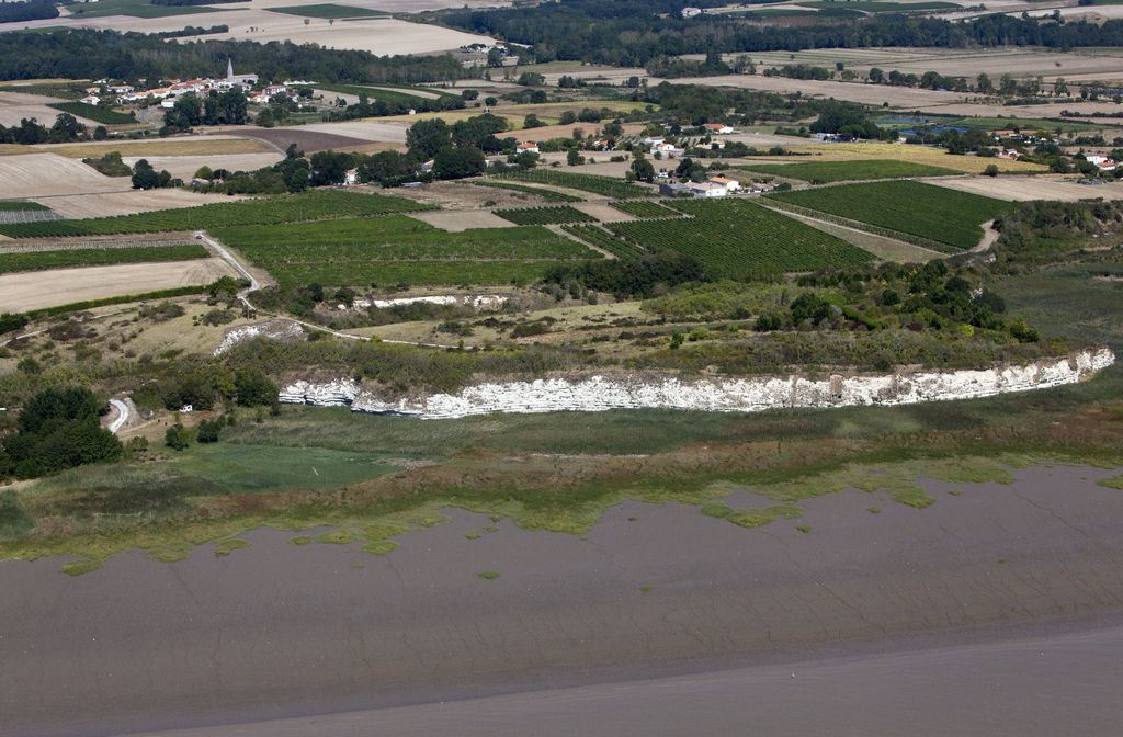 Marais en formation, falaises, vignes, hameaux et bourg, vue aérienne.