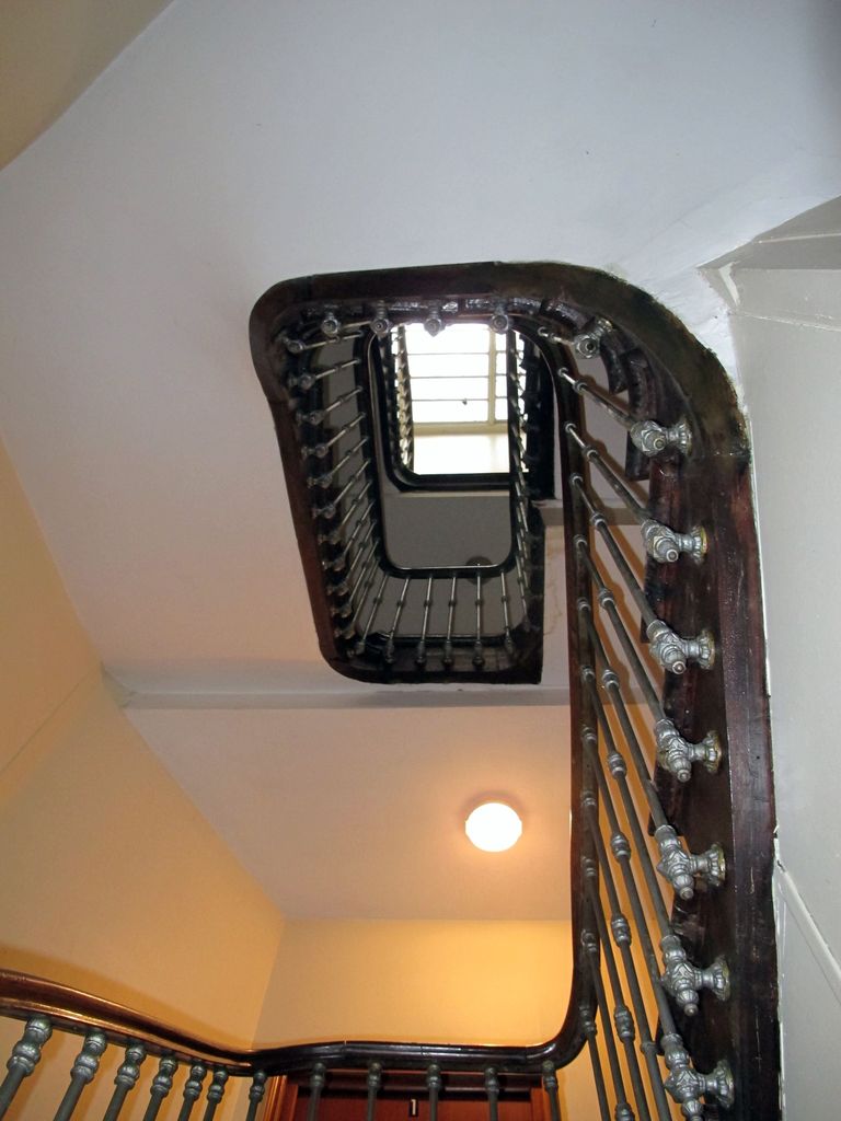 Vue d'ensemble de l'escalier de l'immeuble depuis le rez-de-chaussée.