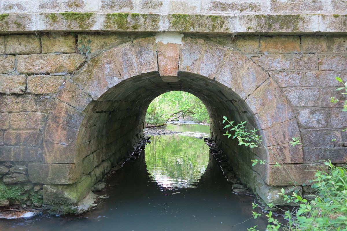 L'arche du pont, depuis l'amont. Le ruisseau du Moulin-de-Pindray sillonne d'ouest en est le territoire de la commune.